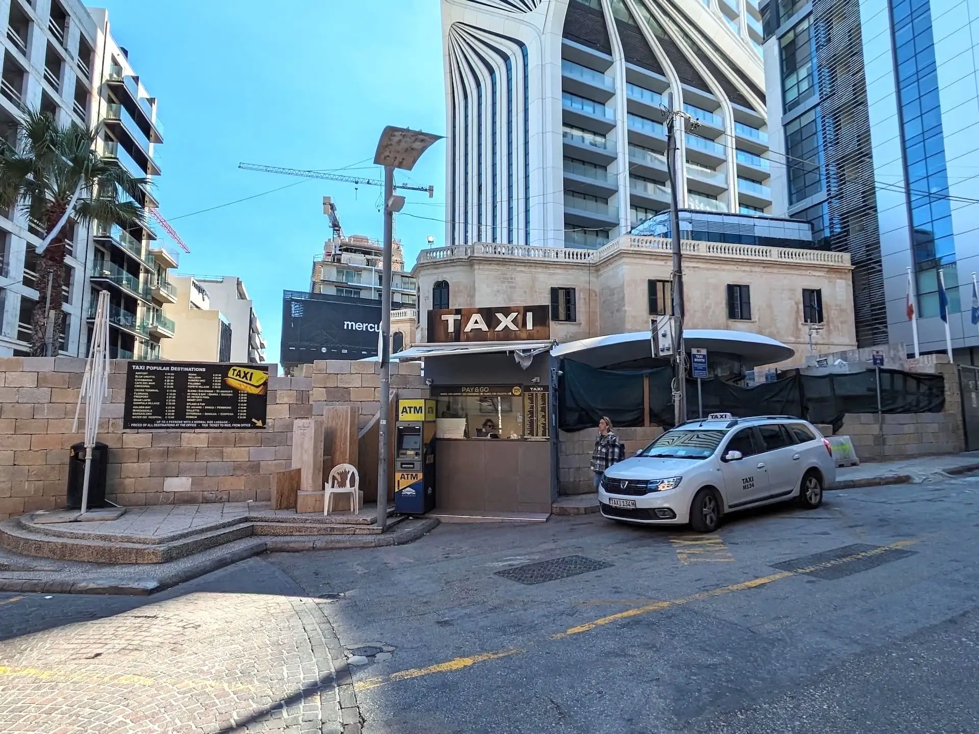 White taxi waiting in front of St. Julian's station in Malta