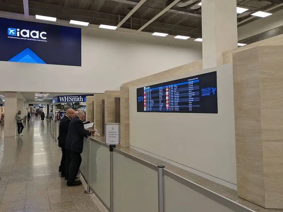 Deux chauffeurs attendent à la sortie des arrivées de l'aéroport de Malte