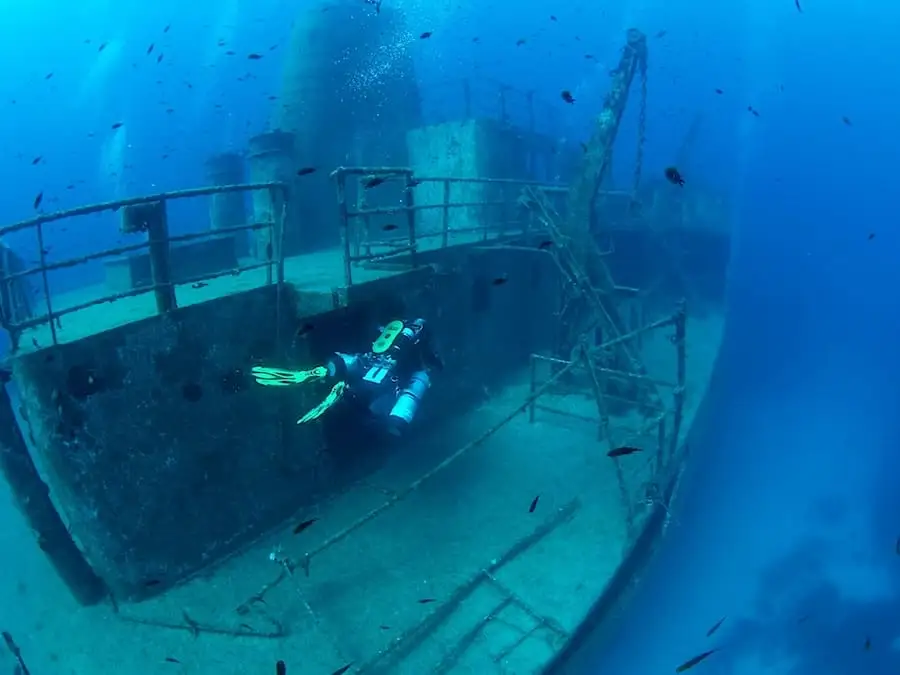 Un plongeur devant une épave de bateau à Malte